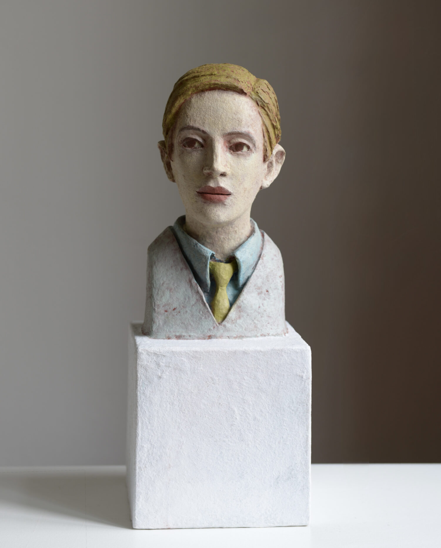 Junger Mann mit grünem Schlips (2025) Paper, glue, quartz sand, pigments, oil; 39 x 15 x 15 cm